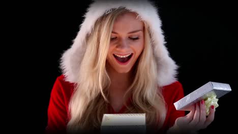 sexy girl in santa costume opening a gift