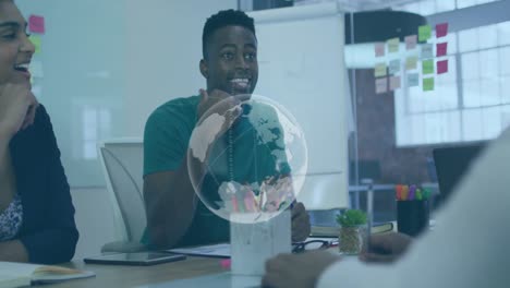 animation of globe icon spinning over african american man talking to his colleagues at office