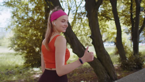 Back-view-of-athletic-sport-runner-girl-training-marathon-run,-starting-race-showing-thumbs-up