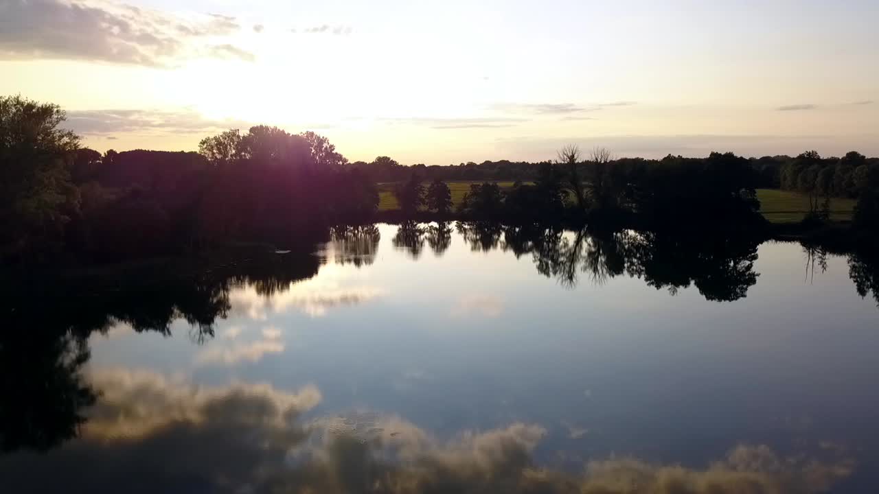 vuelo aéreo suave de drones que se levantan lentamente disparados por drones al atardecer de verano en un lago en un pequeño pueblo en brandeburgo, alemania