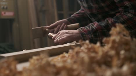 carpenter working with pouch in moody workshop