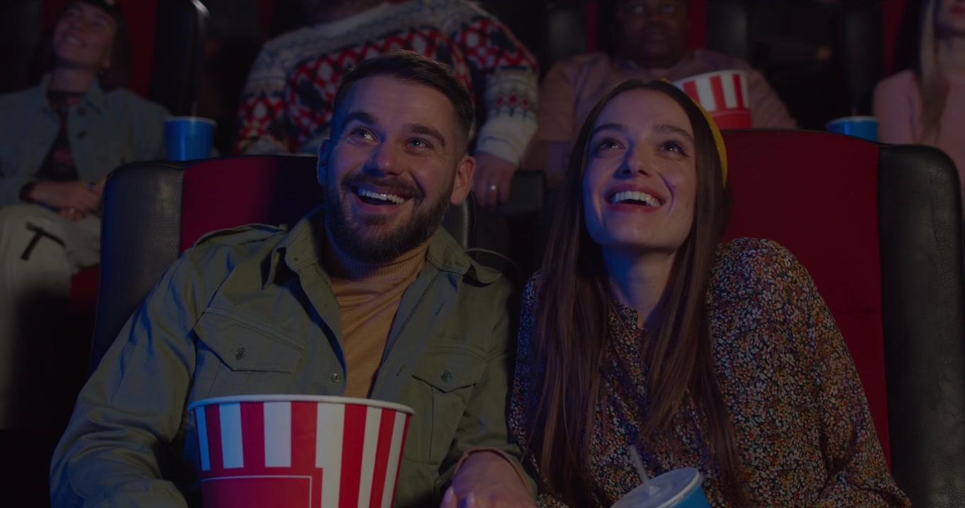 Giovane coppia che guarda un film al cinema