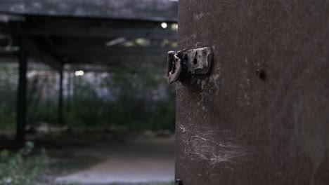 view of derelict building through rusty old door medium tilting shot