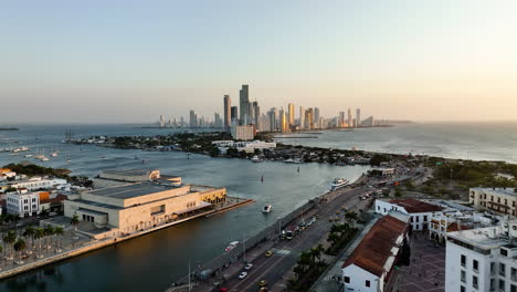 aerial view rising over streets of centro, towards the bocagrande skyline, sunset in cartagena, colombia