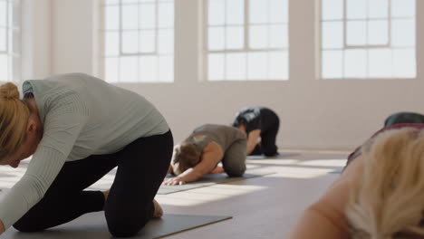 Yoga-Kurs-Von-Gesunden,-Reifen-Frauen,-Die-Die-Pose-Ihres-Kindes-Praktizieren-Und-Das-Morgendliche-Körperliche-Fitnesstraining-Im-Studio-Genießen