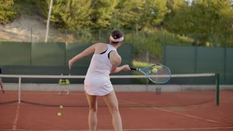 woman tennis player practicing hitting the ball with the coach hitting the ball with a racket in slow motion. professional tennis player training.