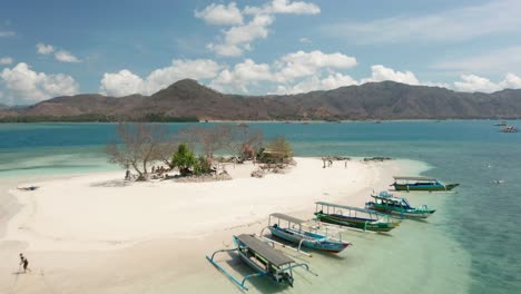 volando sobre la pequeña isla gili kedis con barcos locales en la costa para turistas, aéreos