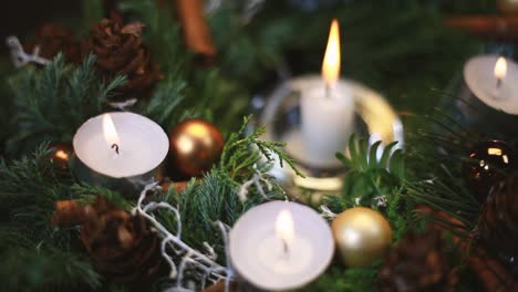 the woman lights a candle on an advent wreath, the background slightly blurred