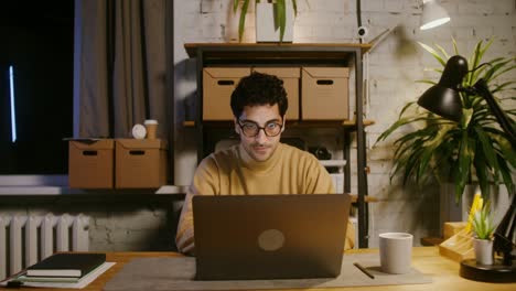 hombre feliz trabajando hasta tarde en la oficina de casa