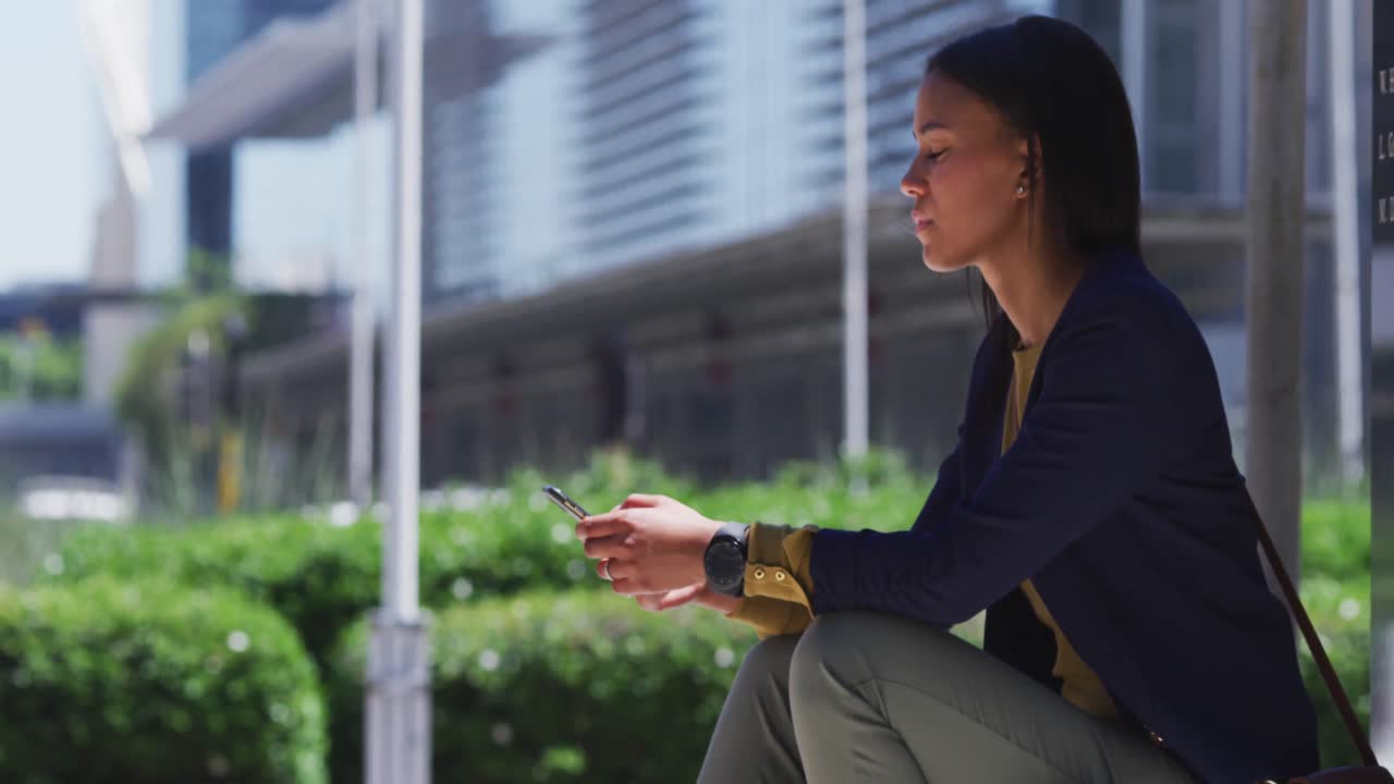 mujer afroamericana usando un teléfono inteligente en la calle