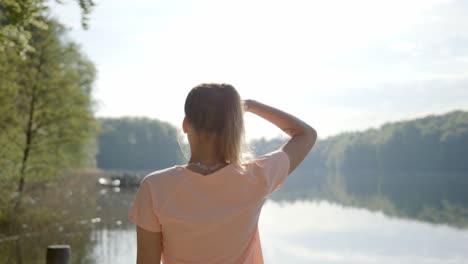 Mujer-Caminando-A-La-Orilla-Del-Lago-Y-Viendo-El-Agua-En-Un-Día-Soleado