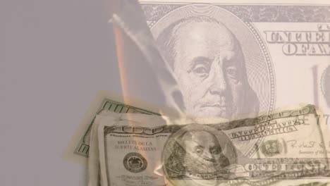 animation of american dollar banknote burning over american dollar banknotes falling