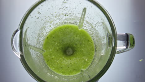 veggies cocktail mixing blender closeup top view. vitamin blend swirling in bowl