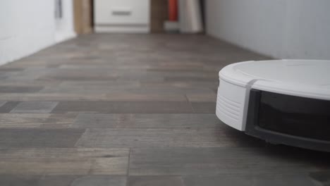 el robot aspirador automático se mueve a lo largo de su trayectoria. robot aspirador limpieza automática en el hogar. casa inteligente. moderno aspirador robótico limpia el piso. toma de primer plano. tecnologías modernas