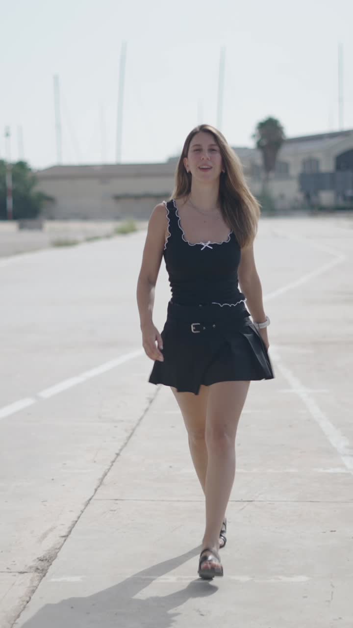 Donna in canotta e gonna che cammina all'aperto