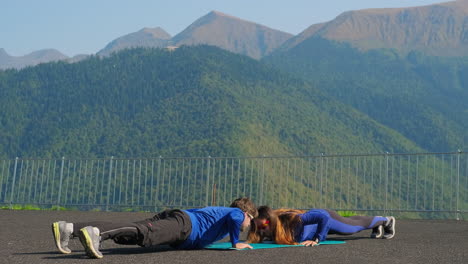 couple doing push-ups in the mountains
