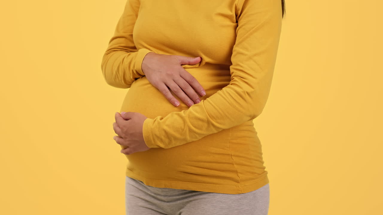 Беременная женщина, касаясь ее живот