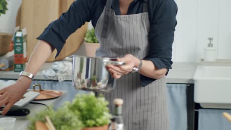 crop woman cooking risotto in pan in kitchen