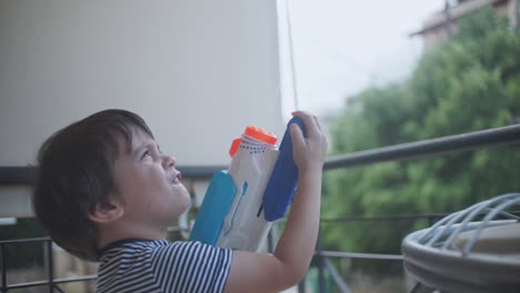 Aufnahmen-Eines-Kleinen-Kaukasischen-Jungen,-Der-Mit-Einem-Wasserpistolenspielzeug-Spielt