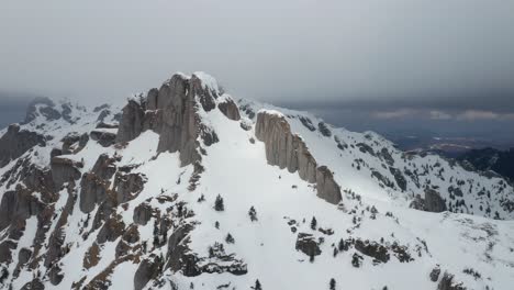 montañas de ciucas cubiertas de nieve bajo un cielo nublado, vista aérea