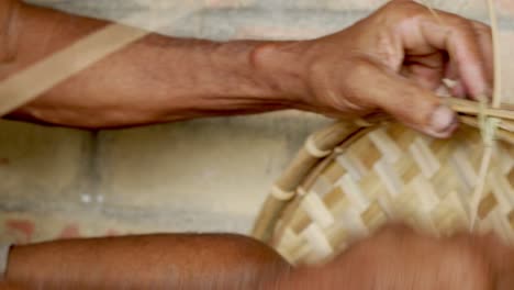 manos masculinas asiáticas hábiles de cerca artesano haciendo sombrero de palo de bambú