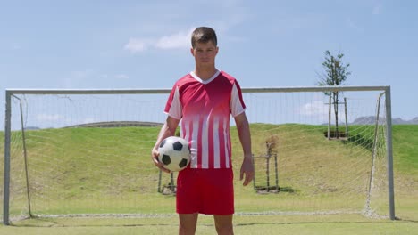 soccer player standing with the ball on the field