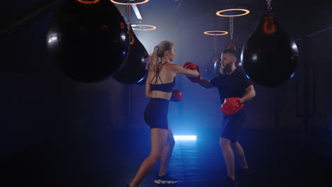 woman and man boxing training session in a gym
