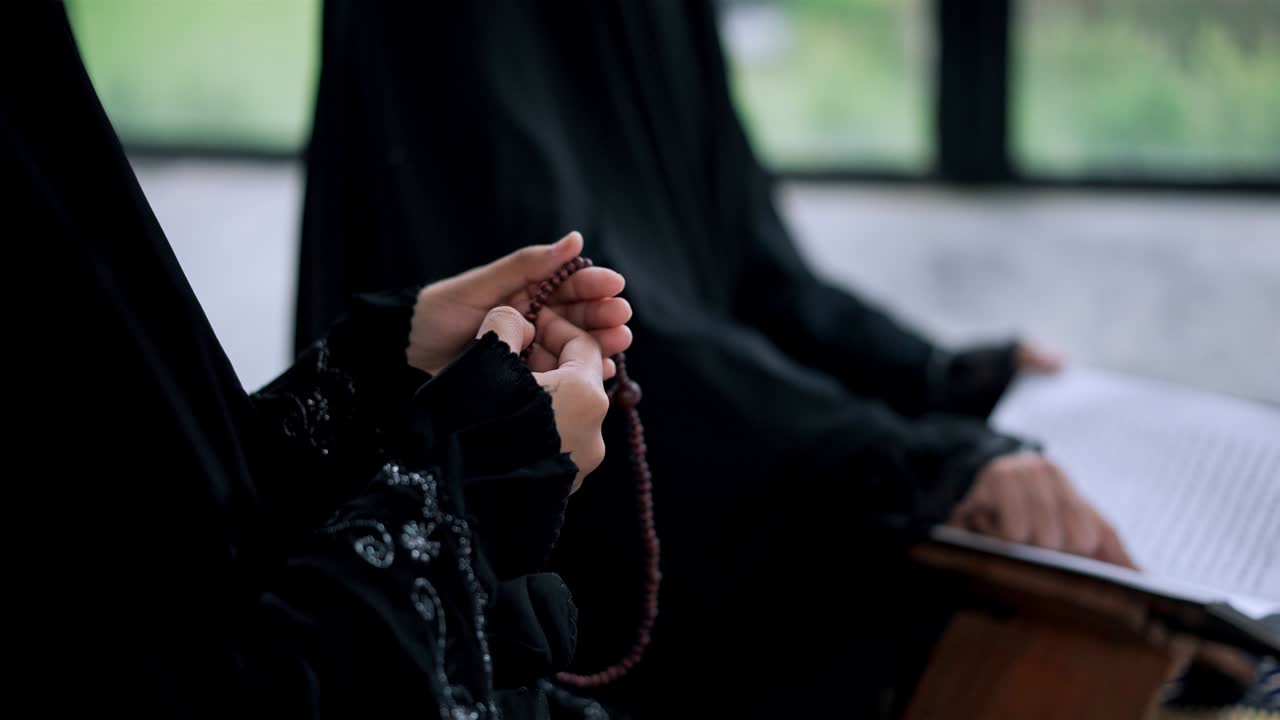 쿠란을 읽는 동안 젊은 무슬림 여성의 손을 가까이 들고