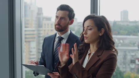 Two-partners-discussing-partnership-standing-office-closeup.-Businesspeople-work