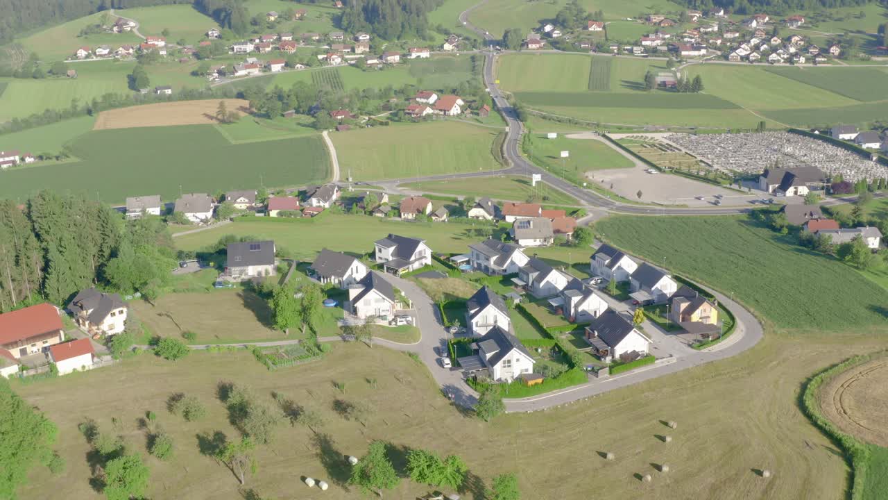 Smuk luftfoto af hytter og sommerhuse omgivet af grønne marker i Slovenj Gradec, Slovenien