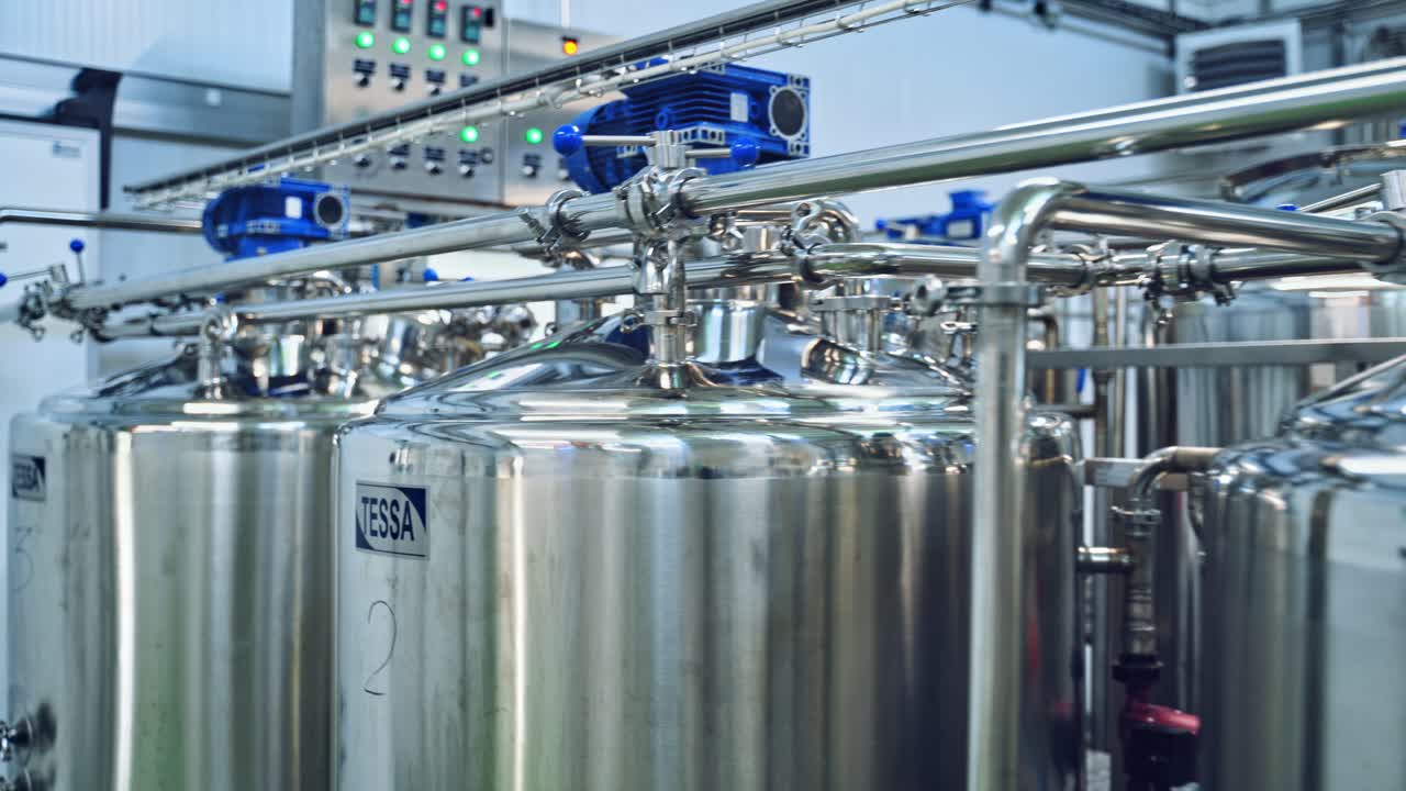 Modern technology of making organic cheese in the dairy factory. Special equipment for making delicious milk products inside the manufacture plant.