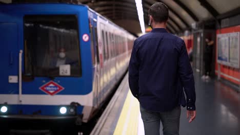 pasajero anónimo caminando en la plataforma cerca del coche de metro que llega