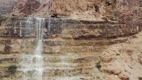 Israel,-desert-waterfall-after-rain,-flood-water,-drone-fly-up-reveal-shot