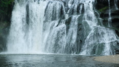 A-waterfall-cascades-in-a-tropical-rainforest-with-rock