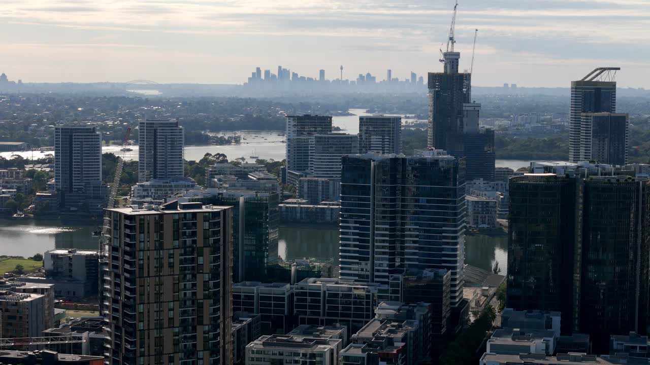 도시 창: 아침 빛에 멀리 떨어진 도시 배경과 함께 강 위에 아오르는 반이는 마천루