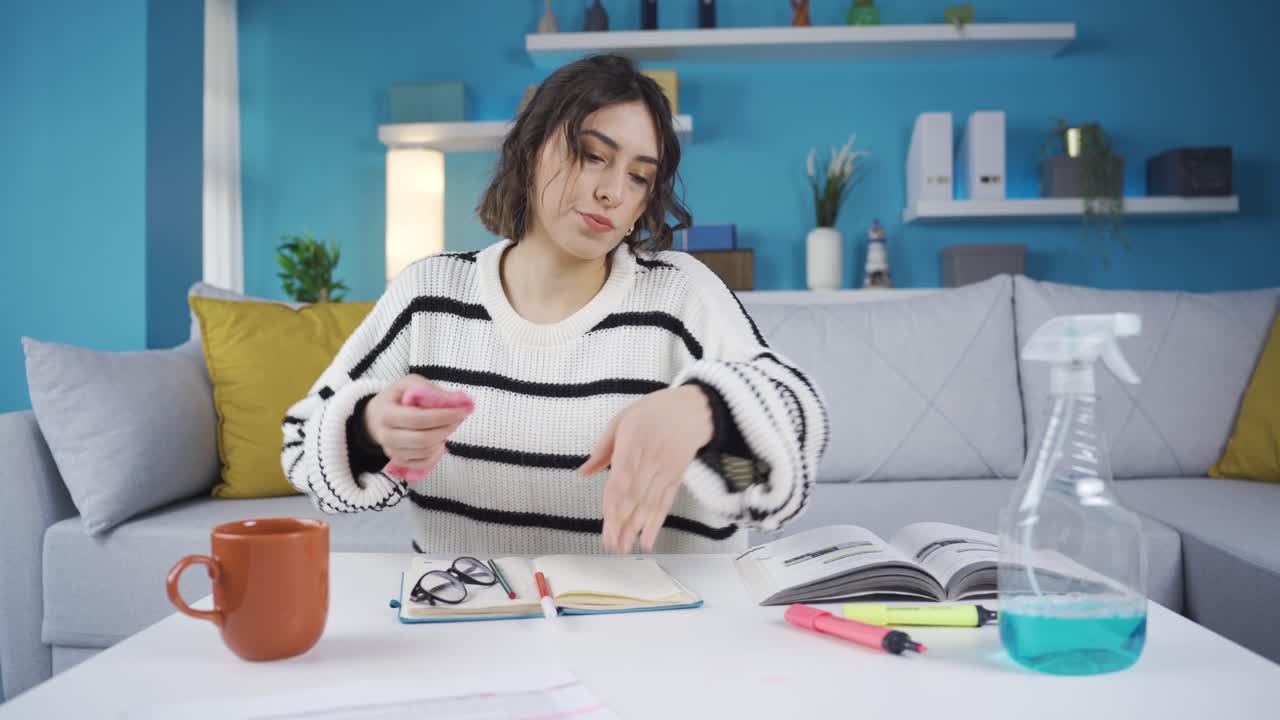 mujer limpiando la mancha de lápiz de color de la mesa con un paño. pintó accidentalmente la mesa.