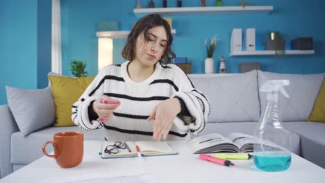 mujer limpiando la mancha de lápiz de color de la mesa con un paño. pintó accidentalmente la mesa.