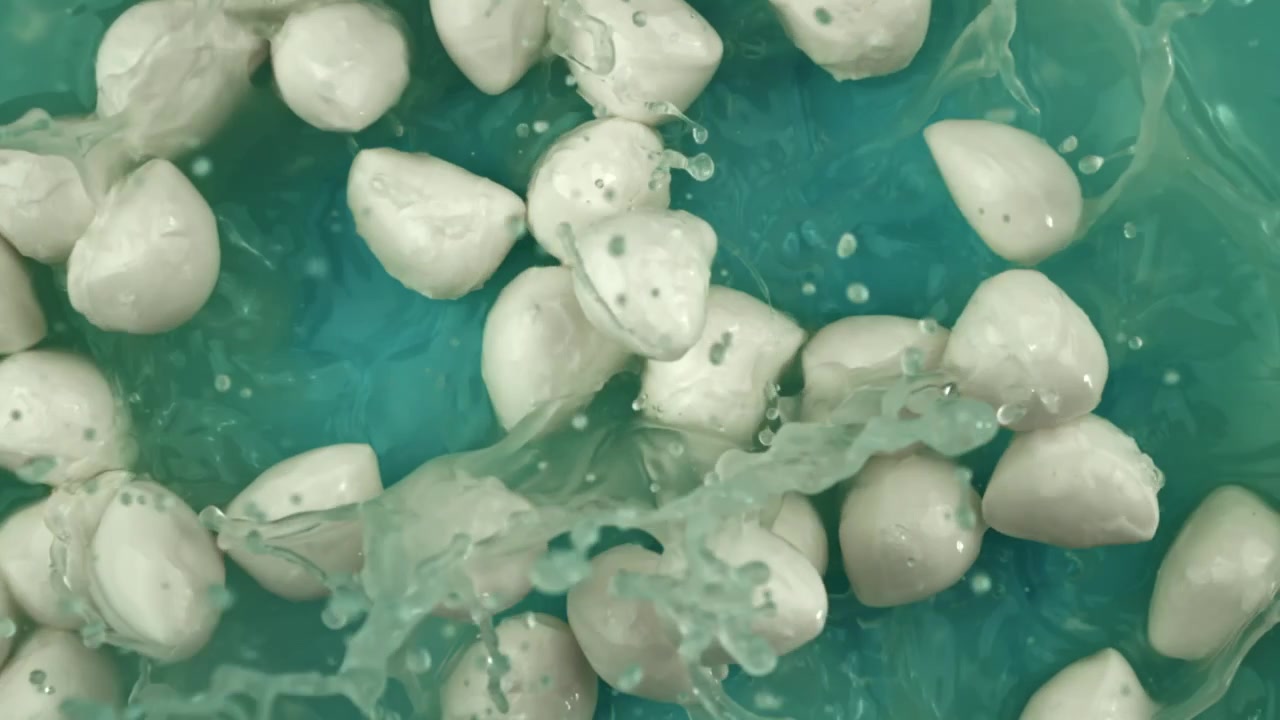 Friske mozzarellakugler plasker ned i turkist vand i slowmotion