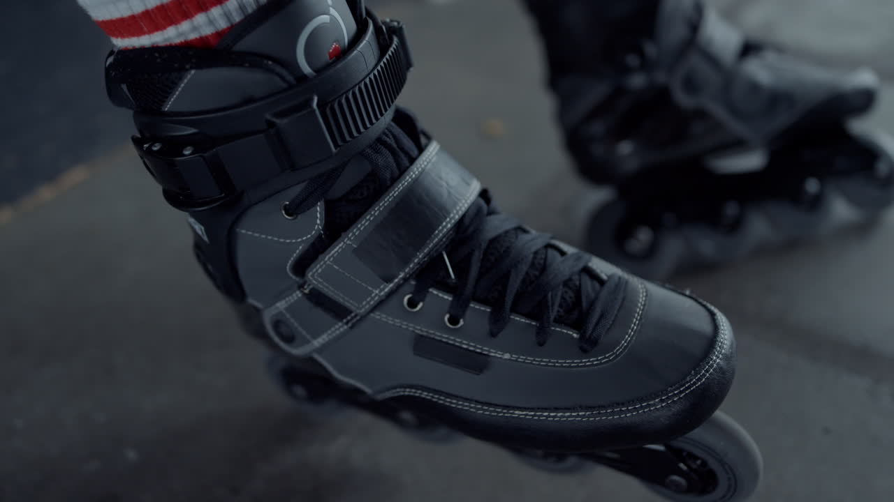 Active teenager putting on roller skates at skate park. Male legs roller blades