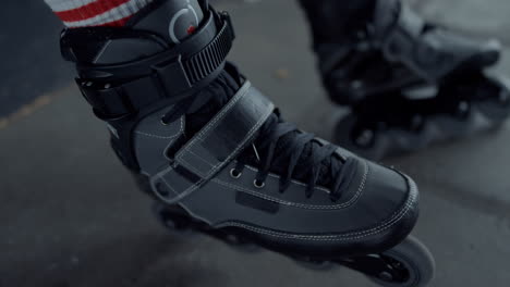 active teenager putting on roller skates at skate park. male legs roller blades