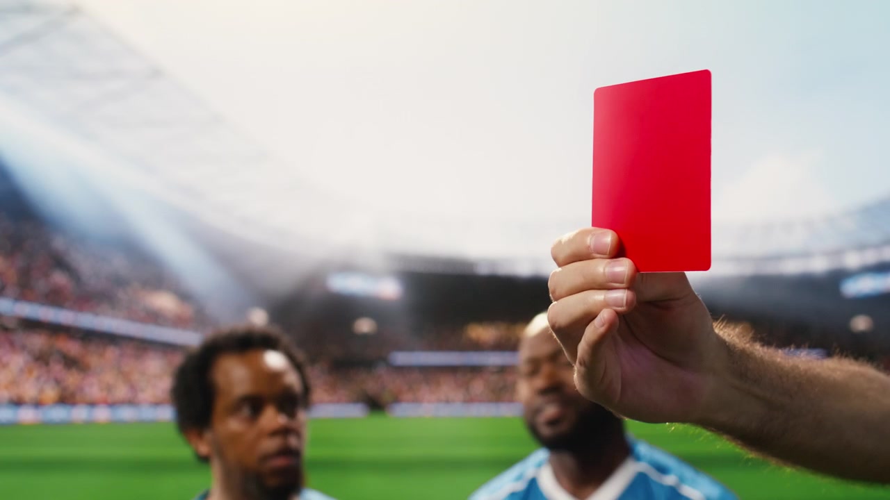 Close up of red card shown by referee as foul punishment during football match