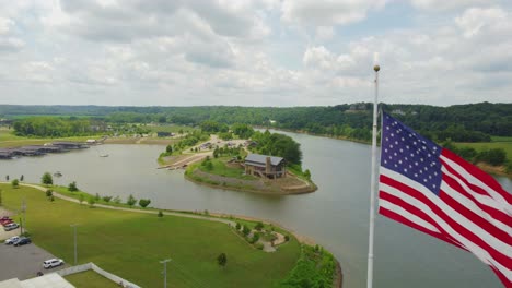 Volando-Más-Allá-De-Una-Bandera-Estadounidense,-En-Dirección-Al-Puerto-Deportivo-De-Clarksville-En-Clarksville,-Tennessee