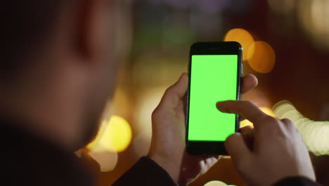 Guy-hand-scrolling-phone-green-screen-outdoor.-Man-touching-screen-mock-up-phone