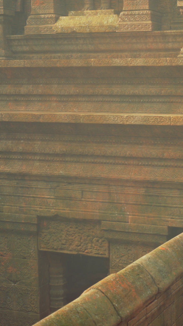 Golden light illuminates intricate carvings on weathered stone steps