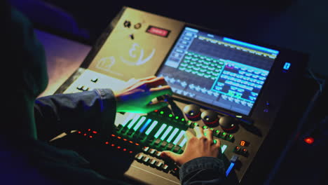 lighting technician operating a stage lighting console