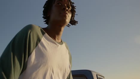 hombre sentado en el maletero de una camioneta en la playa 4k