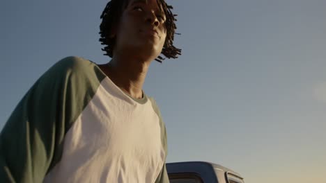 man sitting on trunk of pickup truck at beach 4k