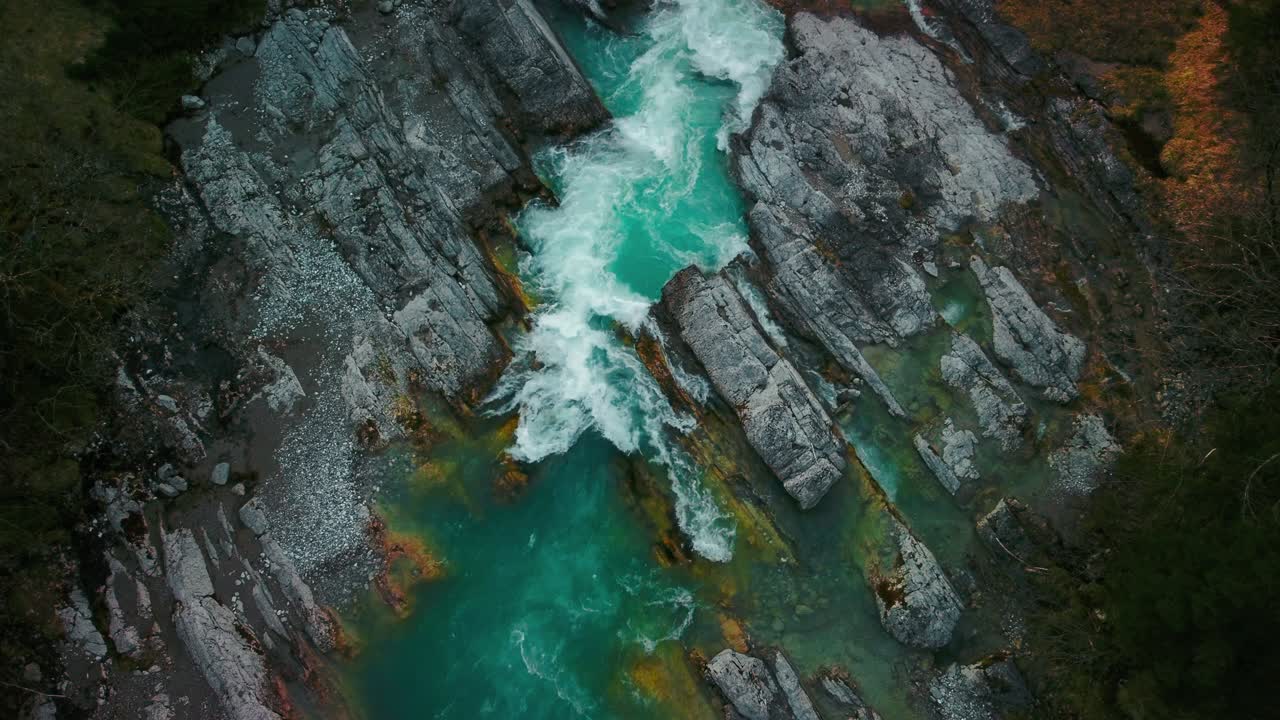 cinemagraph bucle de video aéreo sin fisuras de un pintoresco e idílico cañón de cascada de río de montaña con agua azul fresca en los alpes austriacos de baviera, fluyendo por un hermoso bosque natural a lo largo de árboles vistos desde la perspectiva aérea de las aves.