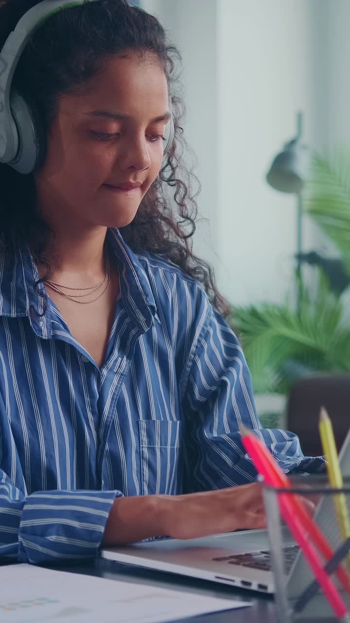 Student focuses on studies with headphones in bright space