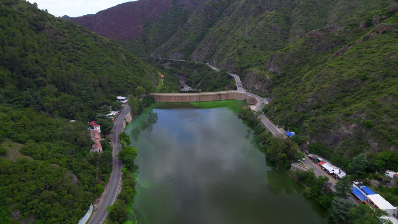 Aerial view of San Roque Lake and Dam surrounded by green mountains. Argentina